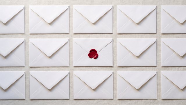 A grid of plain white envelopes, one sealed with red wax